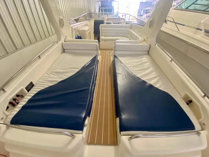 Tude Yacht Photos Pics 1995 Sunseeker Apache 45 interior with white seating and blue covers.