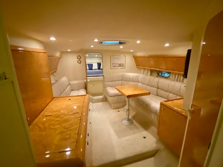 Tude Yacht Photos Pics Interior of 1995 Sunseeker Apache 45 yacht with plush seating and wooden cabinetry.