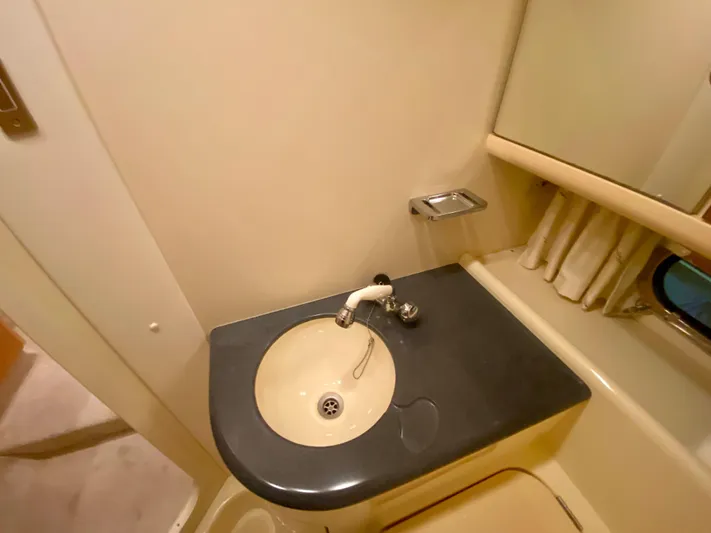 Tude Yacht Photos Pics 1995 Sunseeker Apache 45 bathroom sink with black countertop and mirror.