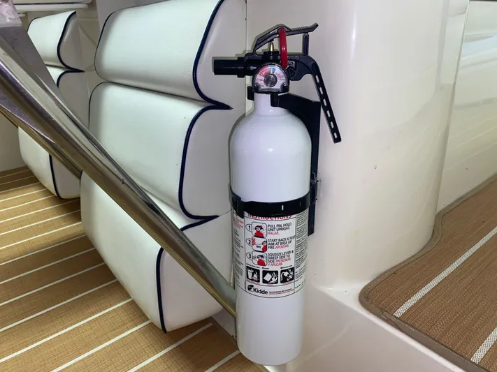 Tude Yacht Photos Pics Fire extinguisher mounted on a 1995 Sunseeker Apache 45 boat with white cushioned seating.