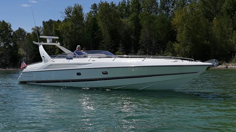 Tude Yacht Photos Pics 1995 Sunseeker Apache 45 yacht cruising on a serene lake with lush green trees.