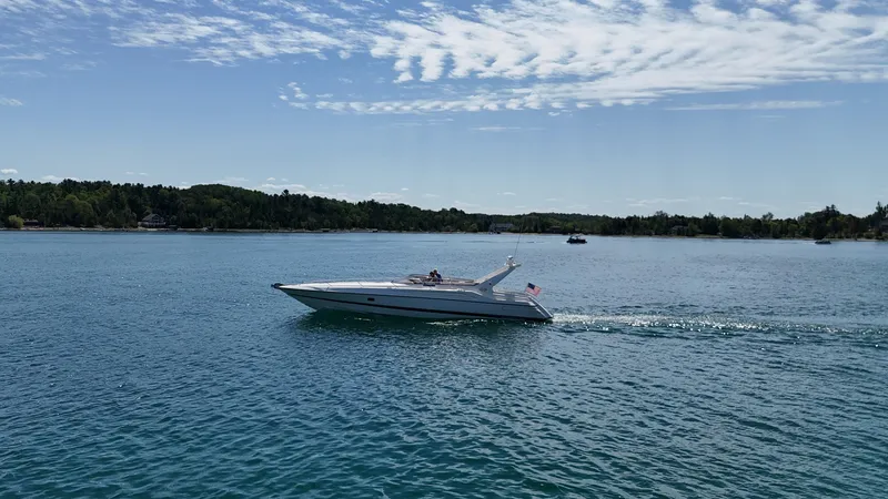 Tude Yacht Photos Pics 1995 Sunseeker Apache 45 cruising on a serene lake under a clear sky.