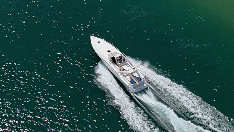 Tude Yacht Photos Pics Aerial view of 1995 Sunseeker Apache 45 yacht cruising on sparkling green water.