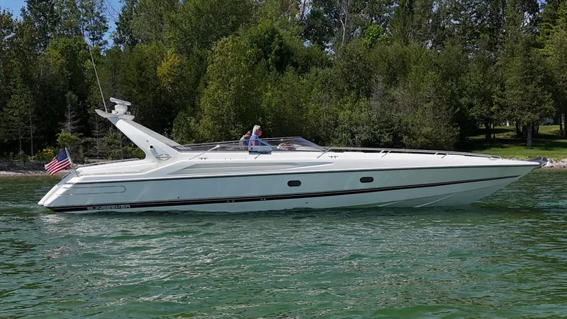 Tude Yacht Photos Pics 1995 Sunseeker Apache 45 yacht cruising on a lake with lush green trees.