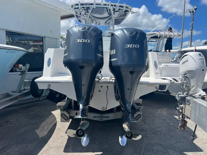  Yacht Photos Pics 2019 Contender 32 ST boat with twin Yamaha 300 engines, docked under a blue sky.
