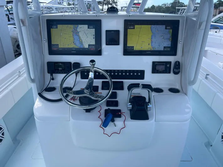  Yacht Photos Pics 2019 Contender 32 ST boat dashboard with dual navigation screens and steering wheel.