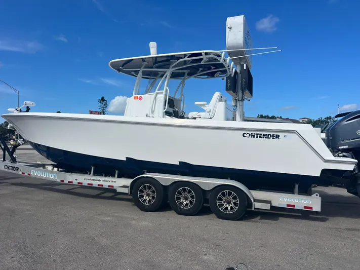  Yacht Photos Pics 2019 Contender 32 ST boat on trailer, white hull, blue accents, parked outdoors.