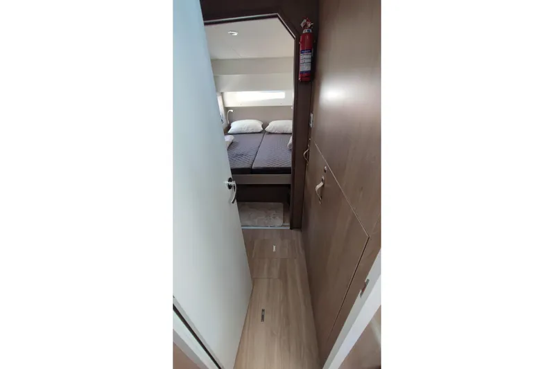  Yacht Photos Pics Interior view of 2023 Bali 4.2 yacht cabin with bed and fire extinguisher.