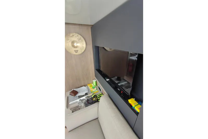  Yacht Photos Pics Interior of 2023 Bali 4.2 yacht with TV, cymbal, and cluttered table.