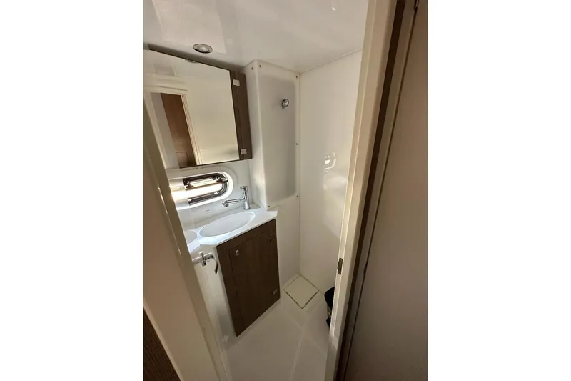  Yacht Photos Pics Compact bathroom in 2023 Bali 4.2 model, featuring sink, mirror, and storage cabinet.