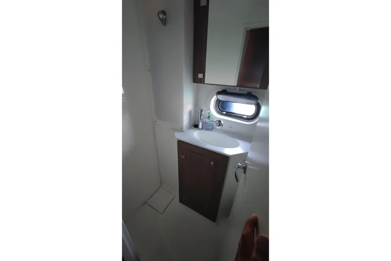  Yacht Photos Pics Modern bathroom interior on 2023 Bali 4.2 yacht, featuring sink, cabinet, and porthole window.