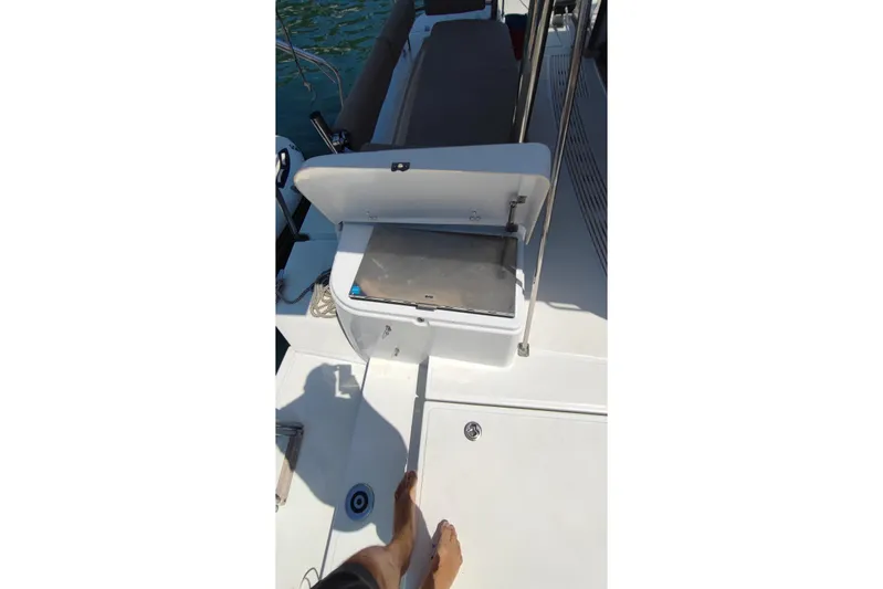  Yacht Photos Pics Open storage compartment on 2023 Bali 4.2 boat deck with visible feet.