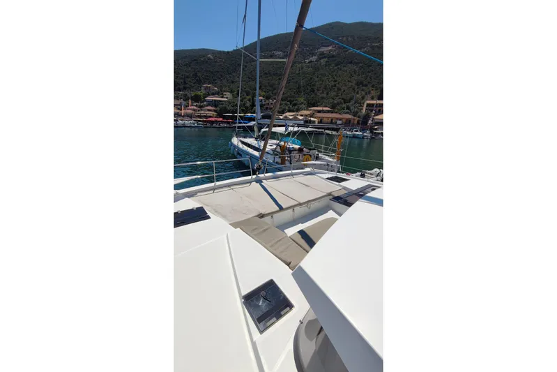  Yacht Photos Pics Sailing yacht Bali 4.2, 2023 model, docked in a scenic marina with lush hills.