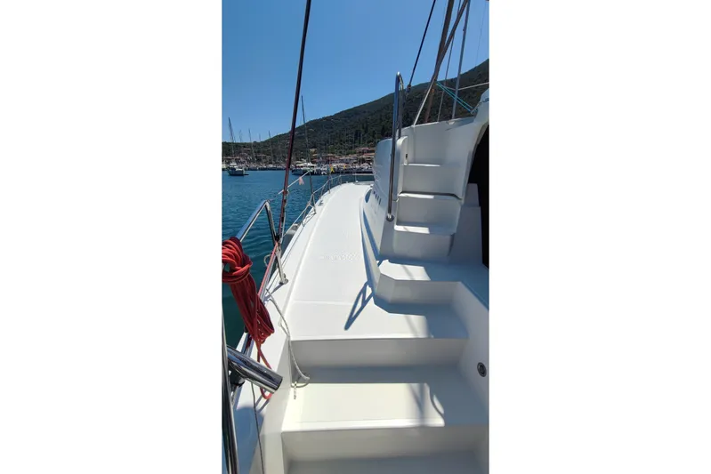  Yacht Photos Pics 2023 Bali 4.2 yacht deck with stairs, docked in a scenic harbor.