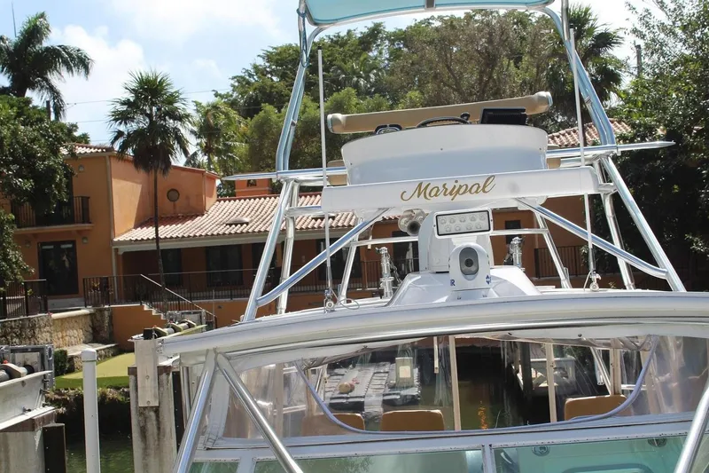 Maripal Yacht Photos Pics 2008 Contender 38 Express boat docked near a tropical house with palm trees.