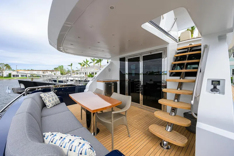Indigo Yacht Photos Pics Luxurious 2018 Coastal Craft Concord 65 yacht deck with seating and wooden stairs.