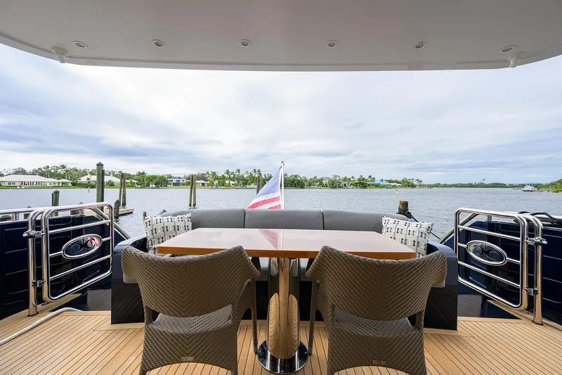 Indigo Yacht Photos Pics Luxury Coastal Craft Concord 65 yacht deck with seating, table, and scenic waterfront view.