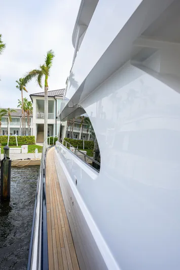 Indigo Yacht Photos Pics Side view of 2018 Coastal Craft Concord 65 yacht docked near waterfront homes.