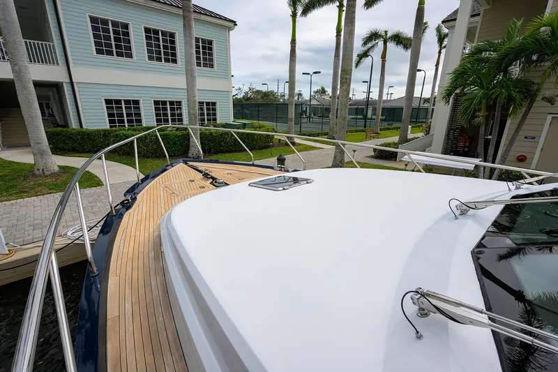 Indigo Yacht Photos Pics Coastal Craft Concord 65 yacht deck, 2018 model, docked near palm trees and buildings.