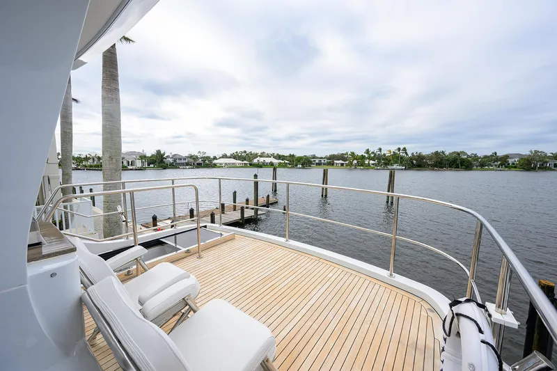 Indigo Yacht Photos Pics Luxury deck view on 2018 Coastal Craft Concord 65 yacht, overlooking serene waterfront.