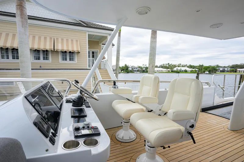 Indigo Yacht Photos Pics Coastal Craft Concord 65 yacht helm with dual seats, 2018 model, docked by waterfront homes.
