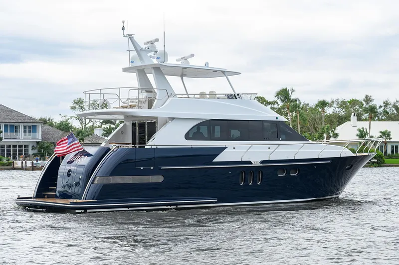 Indigo Yacht Photos Pics 2018 Coastal Craft Concord 65 yacht on water, featuring sleek design and American flag.