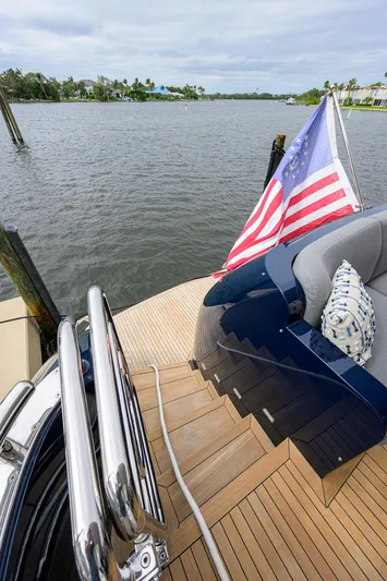 Indigo Yacht Photos Pics 2018 Coastal Craft Concord 65 yacht with American flag on deck, scenic waterfront view.