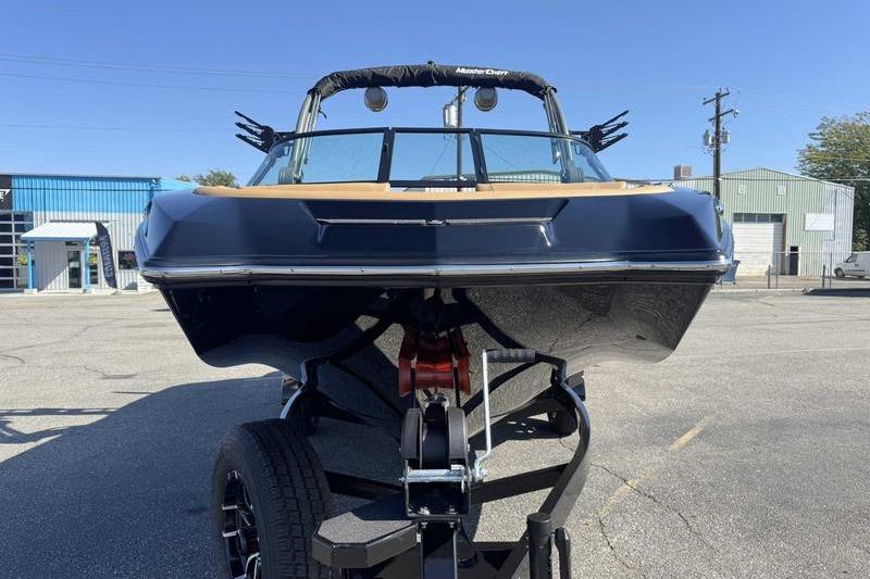 2026 MasterCraft NXT22 boat on trailer in industrial area.