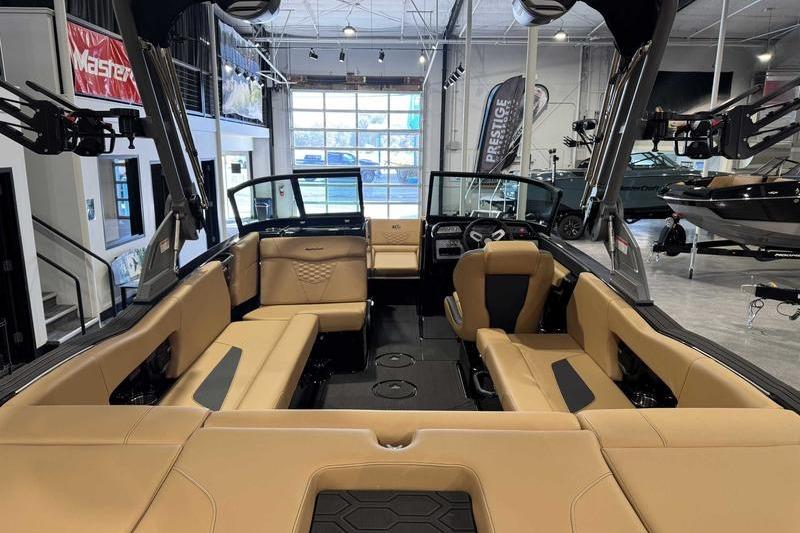 2026 MasterCraft NXT22 boat interior with tan seating in a showroom.