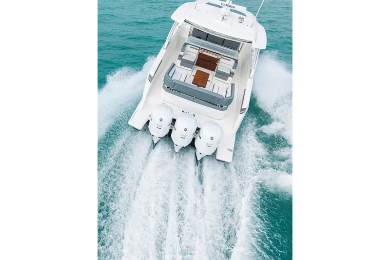 Yacht Photos Pics 2020 Tiara Sport 38 LS boat cruising on turquoise water, rear view.