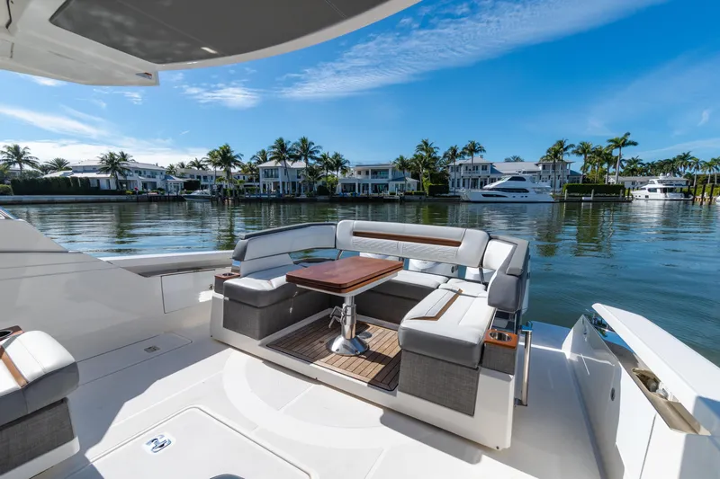  Yacht Photos Pics 2020 Tiara Sport 38 LS yacht with luxurious seating, docked near waterfront homes.