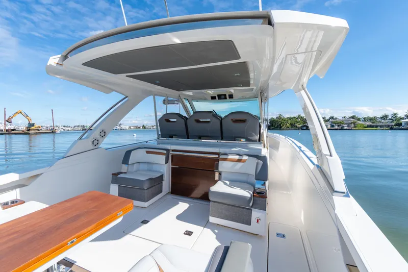  Yacht Photos Pics 2020 Tiara Sport 38 LS luxury boat interior with seating, docked by calm waters.
