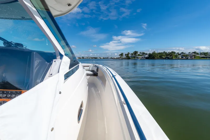  Yacht Photos Pics 2020 Tiara Sport 38 LS boat cruising on a calm, scenic waterway under a clear blue sky.