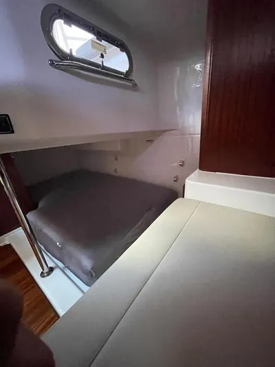 No Name Yacht Photos Pics 2019 Pursuit OS 385 Offshore cabin interior with bed and window.