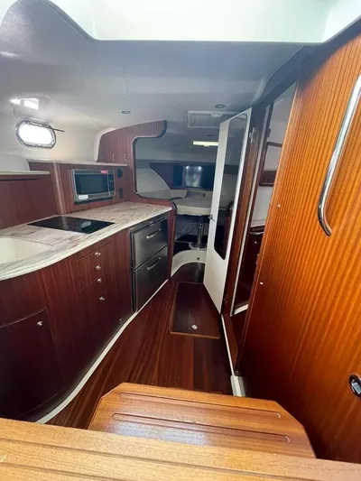 No Name Yacht Photos Pics 2019 Pursuit OS 385 Offshore yacht interior with wood finish and modern kitchen amenities.