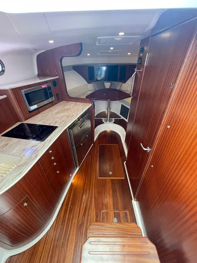 No Name Yacht Photos Pics 2019 Pursuit OS 385 Offshore yacht interior with modern kitchen and wood finish.