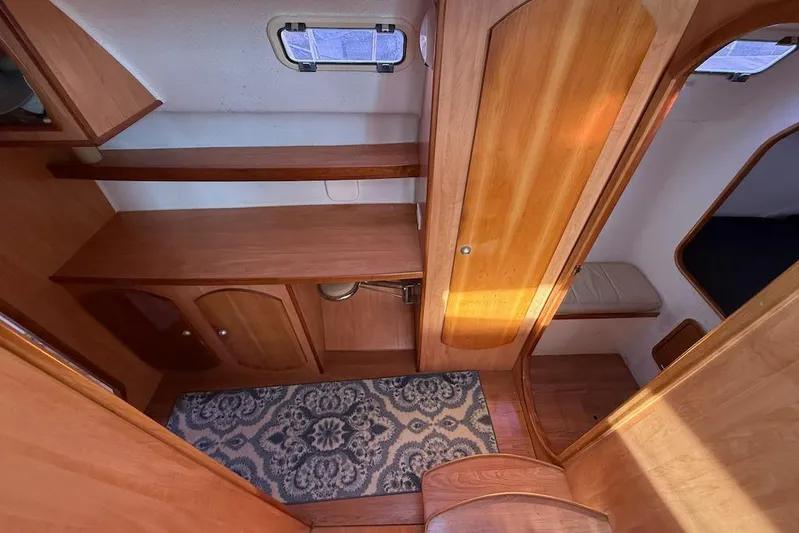 Zimbini Yacht Photos Pics 2006 Island Spirit 401 yacht interior with wooden cabinetry and patterned rug.