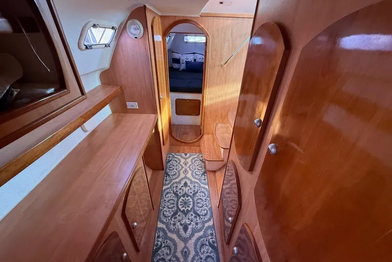 Zimbini Yacht Photos Pics Interior of 2006 Island Spirit 401 yacht with wooden cabinetry and patterned carpet.