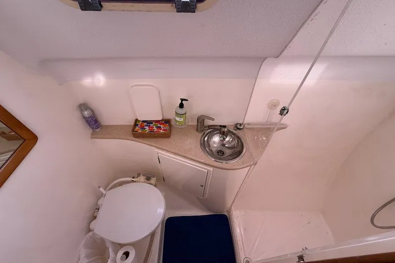 Zimbini Yacht Photos Pics Compact bathroom in 2006 Island Spirit 401 yacht with sink, toilet, and toiletries.