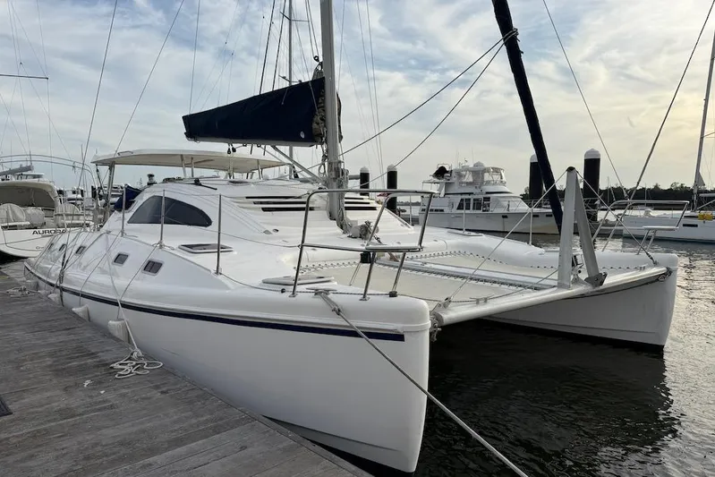 Zimbini Yacht Photos Pics 2006 Island Spirit 401 catamaran docked at marina, featuring sleek design and spacious deck.