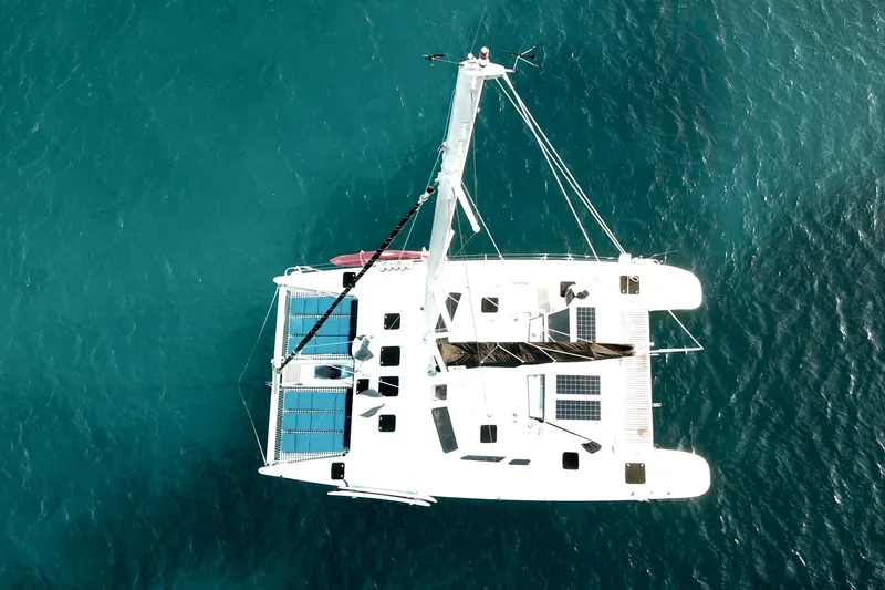 Turquoise Turtle Yacht Photos Pics Aerial view of 2001 Voyage 500 catamaran with solar panels on turquoise water.
