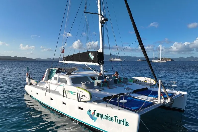 Turquoise Turtle Yacht Photos Pics 2001 Voyage 500 catamaran "Turquoise Turtle" sailing in clear blue waters under a sunny sky.