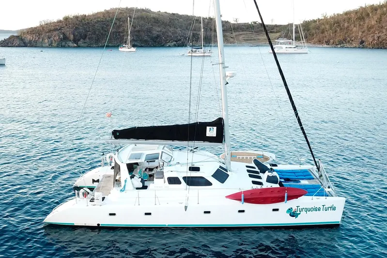 Turquoise Turtle Yacht Photos Pics Sailing catamaran Voyage 500, 2001 model, anchored in serene blue waters.