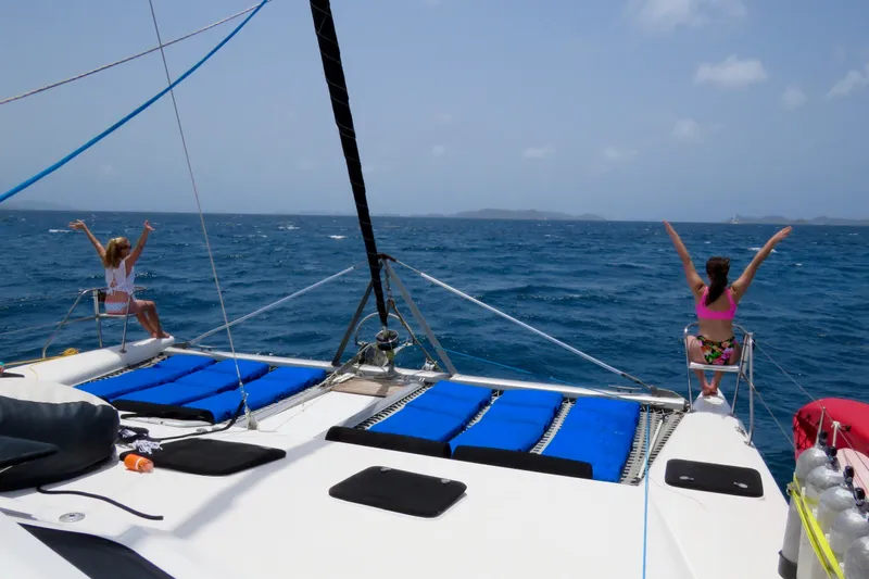 Turquoise Turtle Yacht Photos Pics Two people relaxing on a 2001 Voyage 500 catamaran, enjoying the ocean view.