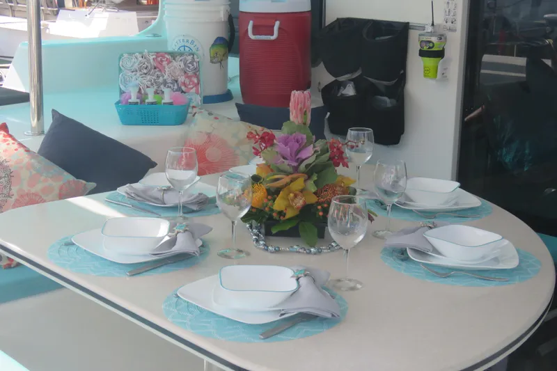 Turquoise Turtle Yacht Photos Pics Elegant dining setup on Voyage 500 yacht, featuring floral centerpiece and stylish tableware.