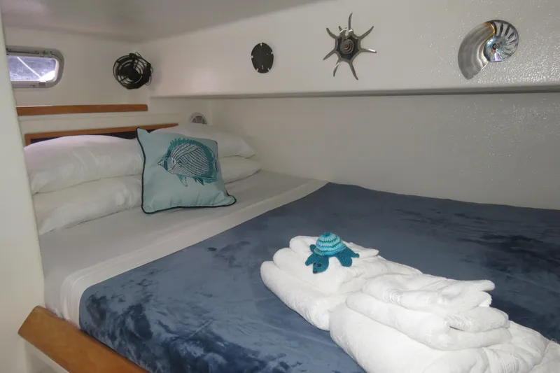 Turquoise Turtle Yacht Photos Pics Cozy cabin interior of 2001 Voyage 500 yacht with nautical decor and plush bedding.