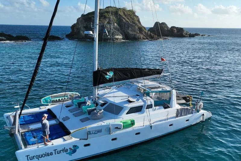 Turquoise Turtle Yacht Photos Pics Catamaran "Turquoise Turtle" sailing near rocky island, Voyage 500 model, 2001.