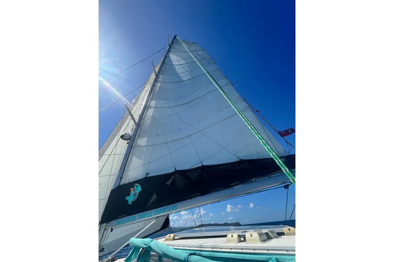 Turquoise Turtle Yacht Photos Pics Sailing yacht Voyage 500, 2001 model, with sunlit sails against a clear blue sky.