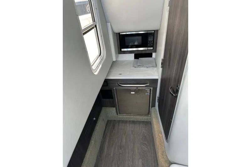 Yacht Photos Pics 2021 Formula 350 Crossover Bowrider OB interior with kitchenette, featuring microwave and compact fridge.