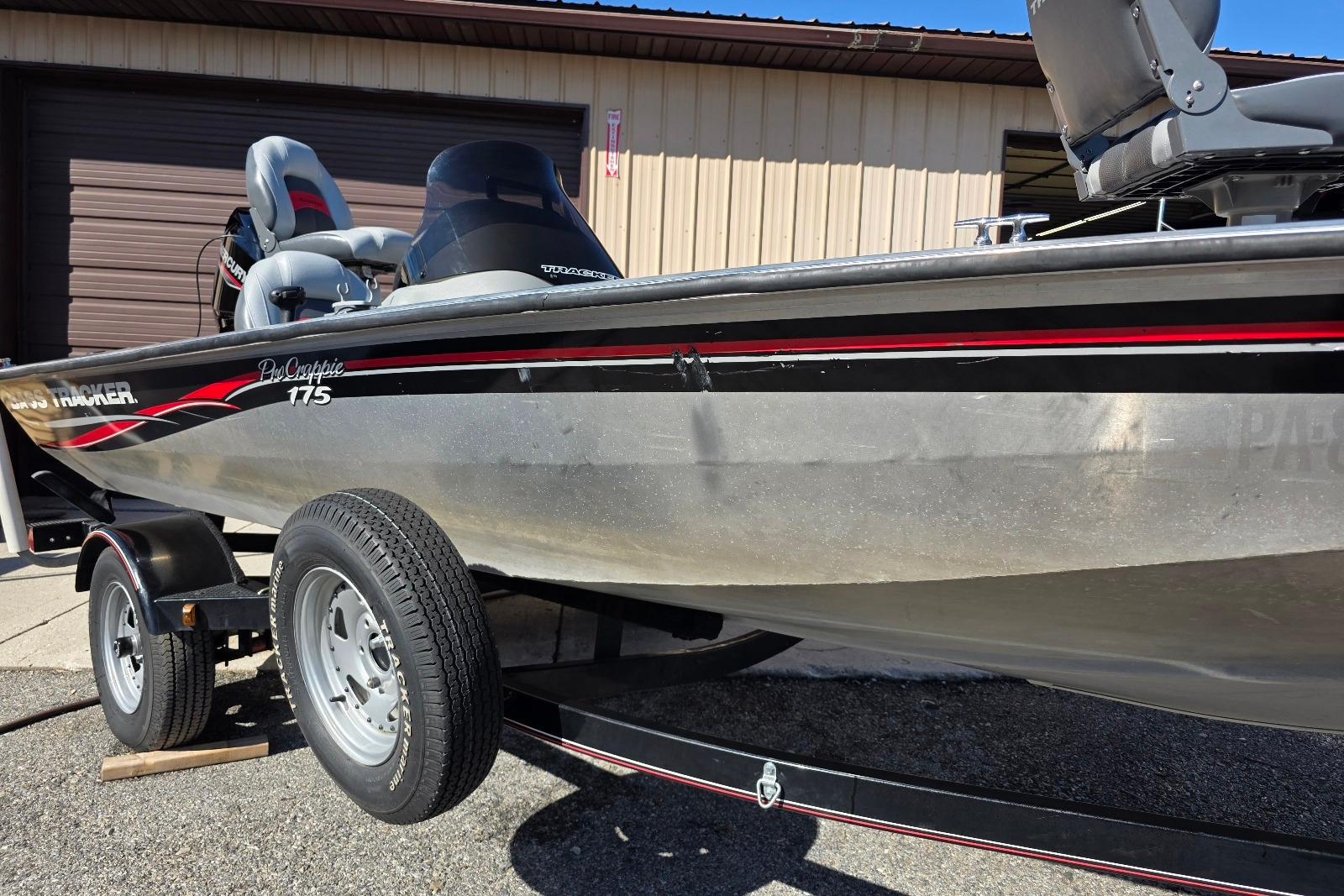 2010 Bass Tracker Pro Crappie 175 boat on trailer, parked outside a garage.